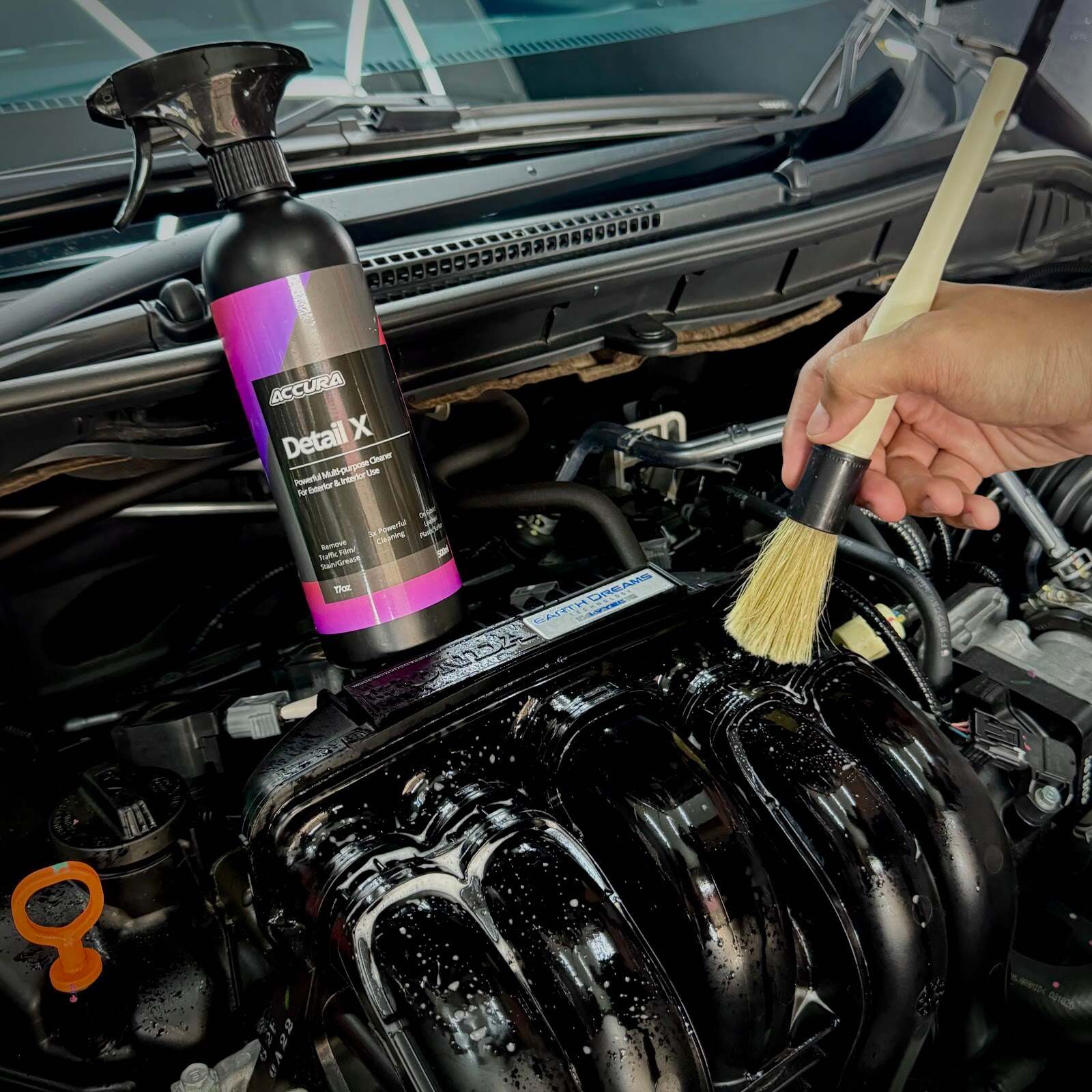 Berus membersihkan ruang enjin di sebelah botol Accura Detail X