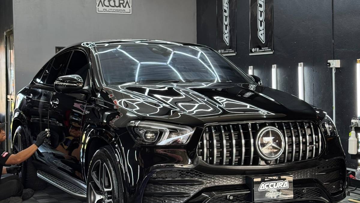 Mercedes-AMG GLE Coupé hitam berkilat memantulkan lampu heksagon di studio Accura, dengan plat ACCURA autospa