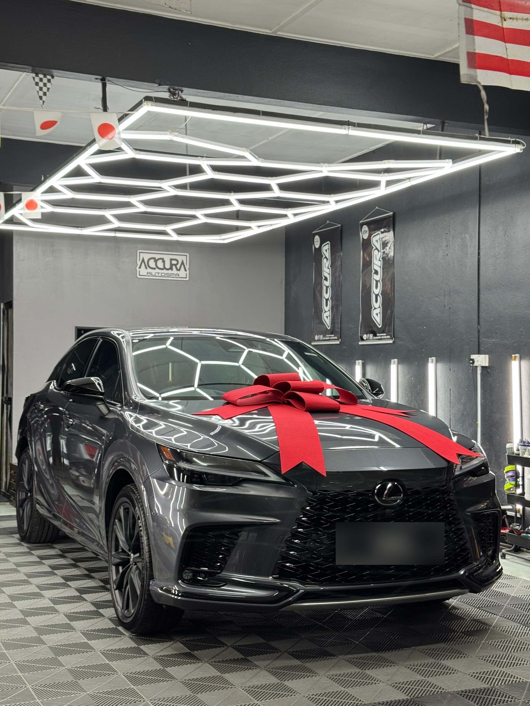Lexus RX500h kelabu dengan reben merah di atas bonet