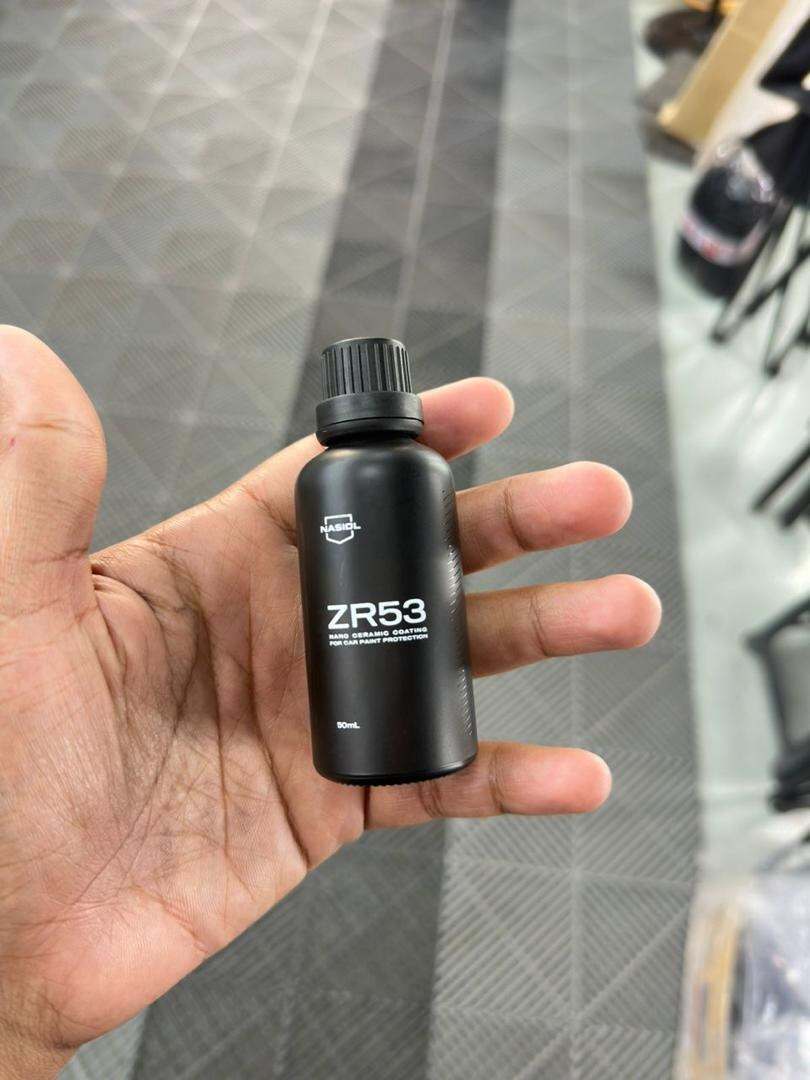 Tangan memegang botol NASIOL ZR53 nano ceramic coating 50 mL di studio Accura