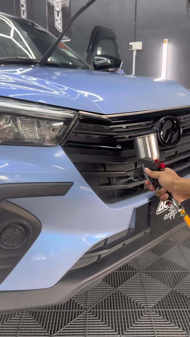 Cecair black trim restoration disembur pada gril Perodua biru
